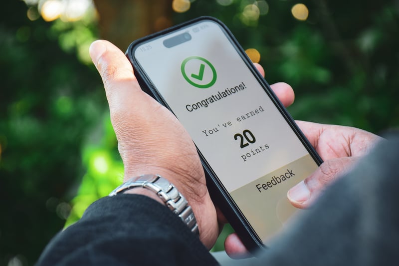 a hand holds a phone with a member rewards program vs. loyalty program
