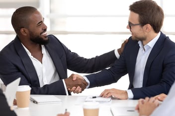 businessmen shake hands over a B2B loyalty program rewards program app