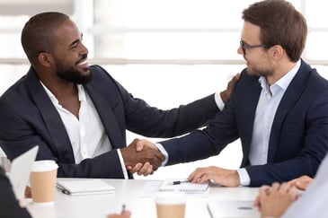 businessmen shake hands over a B2B loyalty program rewards program app