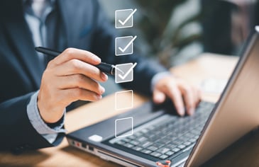 businessman on laptop goes through a reward program software checklist