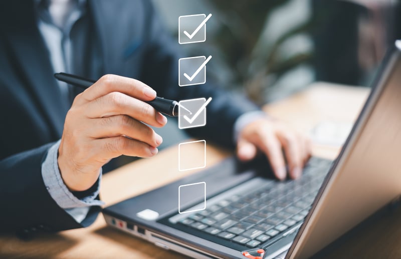 businessman on laptop goes through a reward program software checklist