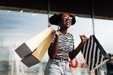A shopper happily holds her bags customer retention