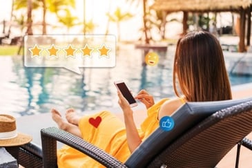 employee sitting by a pool checking her travel reward points