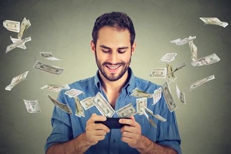 consumer smiles at phone while money flies around showing digital rewards